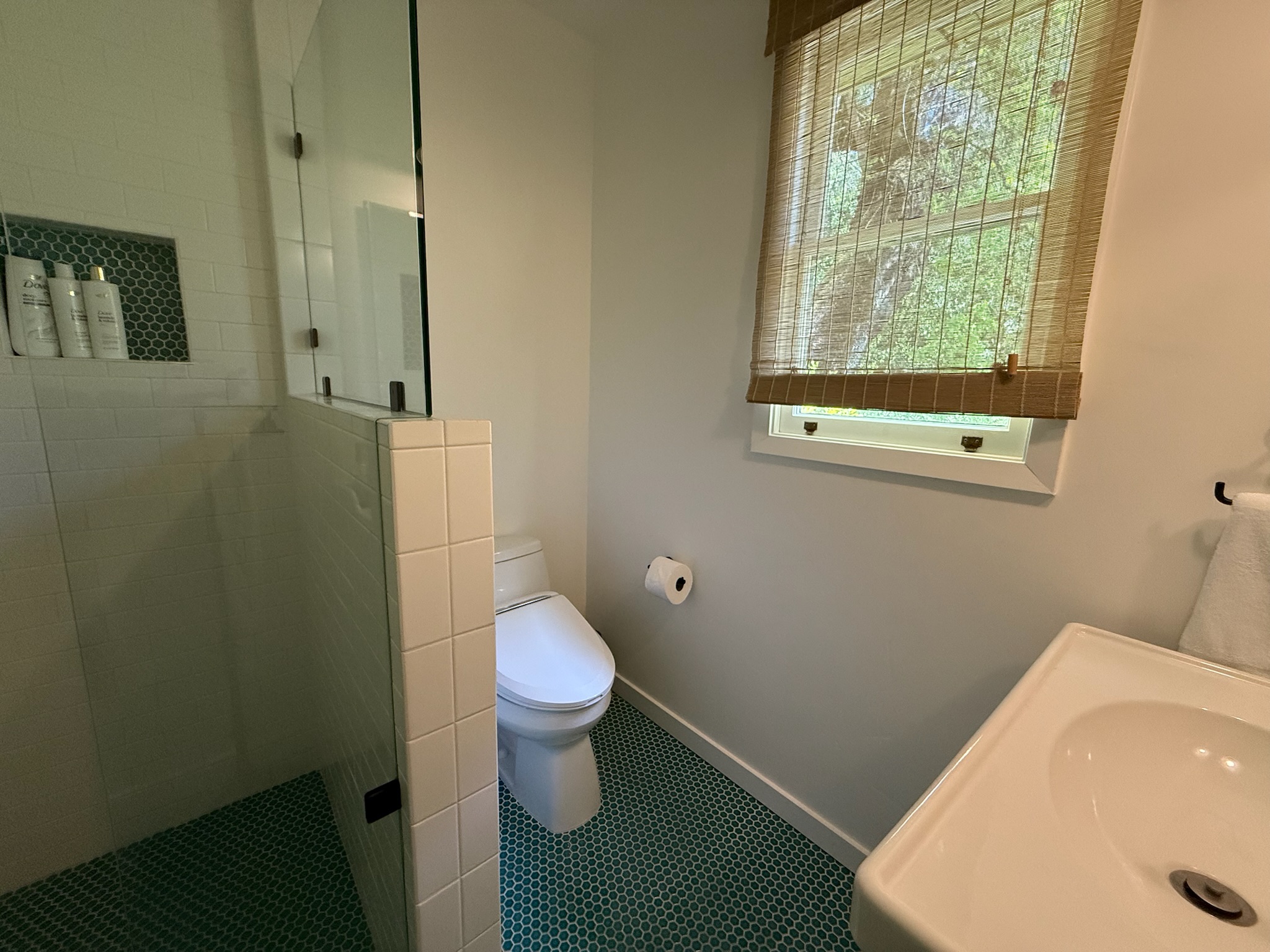 Bright and serene spa-style bathroom, with leafy views and luxurious finishes designed for relaxation.